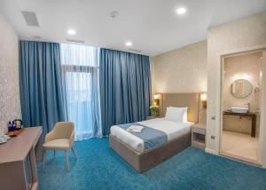 a hotel room with a bed and a desk and a chair at Meta Business Hotel By King David in Tbilisi City