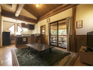 a living room with a table and a kitchen at Log house for 12 people - Vacation STAY 35069v in Minamioguni