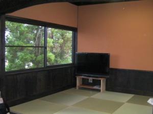sala de estar con TV de pantalla plana y ventana en Log house for 12 people - Vacation STAY 35072v, en Minamioguni