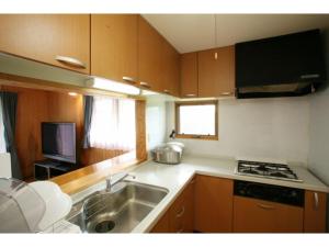 a kitchen with a sink and a stove top oven at Log house for 12 people - Vacation STAY 33957v in Minamioguni