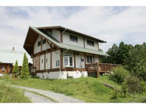 ein Haus auf einem Hügel mit einer Veranda in der Unterkunft Log house for 12 people - Vacation STAY 33957v in Minamioguni