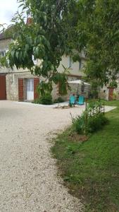Gite de La Pivarderie في Sénillé: منزل فيه كرسيين ازرق في ساحة