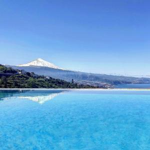 uma grande massa de água com uma montanha ao fundo em Apartamento Teide Piscina Climatizada em Sauzal