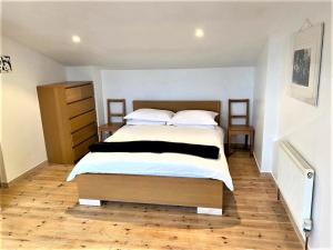 a bedroom with a large bed and a wooden floor at Beautiful Apartment With Terrace Near Kentish Town in London