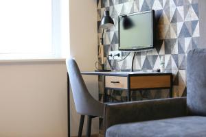 ein Zimmer mit einem Schreibtisch mit Fernseher und einem Stuhl in der Unterkunft Modern 2 Rooms Apartment in Kaunas