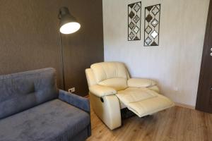 ein Wohnzimmer mit Sessel und Couch in der Unterkunft Modern 2 Rooms Apartment in Kaunas