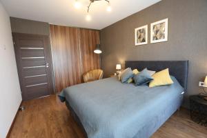 a bedroom with a bed with blue and yellow pillows at Modern 2 Rooms Apartment in Kaunas