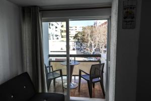 a room with a balcony with a table and chairs at Vina's Beach House - 2 minute walk to the beach in Costa da Caparica