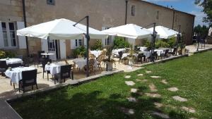 rzędu stołów z białymi parasolami i krzesłami w obiekcie AUX DUCS DE SIENNE w mieście Montagne