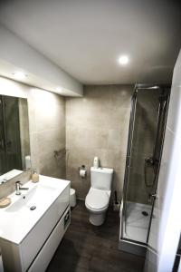 a bathroom with a toilet and a shower and a sink at Vina's Beach House - 2 minute walk to the beach in Costa da Caparica