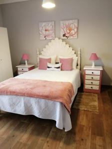 1 dormitorio con 1 cama blanca grande con almohadas rosas en Casa Vaz, en Grândola