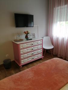 a bedroom with a dresser with a tv on top of it at Casa Vaz in Grândola