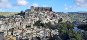 una ciudad en la cima de una colina con un castillo en La Nicchia, en Ragusa