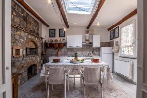 eine Küche mit einem Tisch mit Stühlen und einer Steinmauer in der Unterkunft YourHome - Casa Viva in Colli di Fontanelle