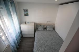 Dormitorio pequeño con cama y vestidor en Vina's Beach House - 2 minute walk to the beach, en Costa da Caparica