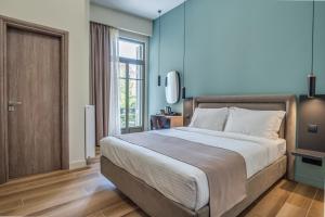 sypialnia z dużym łóżkiem i dużym oknem w obiekcie Philia Boutique Hotel w Atenach