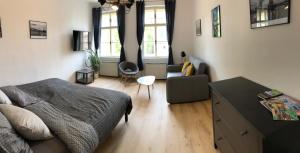 a bedroom with a bed and a living room at Apartmány CAFÉ-CAFÉ in Jičín