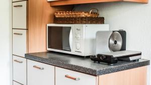 un four micro-ondes installé au-dessus d'un comptoir de cuisine dans l'établissement Ferienwohnung - a Auszeit, à Neumarkt in Steiermark