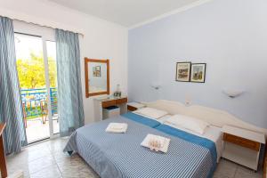 a bedroom with a bed and a large window at Ionio Gastronomy Suites in Ammoudia