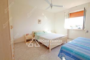 a white room with a bed and a window at GD Case Vacanza - Fronte Mare - in Lido Marini