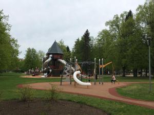 un parque con parque infantil con toboganes y una torre en sunny apartment, en Ventspils