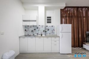 a kitchen with white cabinets and a white refrigerator at Apartments EON Gevgelija in Gevgelija +83 photos