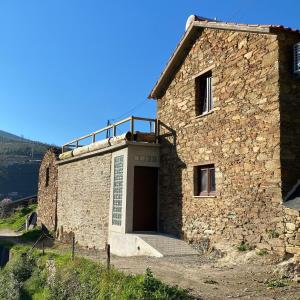 um edifício de pedra com uma porta ao lado em Casa da Alfazema em Arganil
