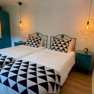 Cette chambre comprend 2 lits avec des oreillers en noir et blanc. dans l'établissement Casa da Alfazema, à Arganil