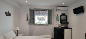 a room with two beds and a window at Anemomylos Houses in Koufonisia