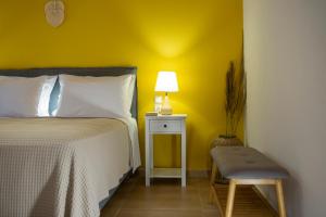 a bedroom with a bed and a lamp and a chair at Pnoes Villas Vasiliki Lefkada in Vasiliki