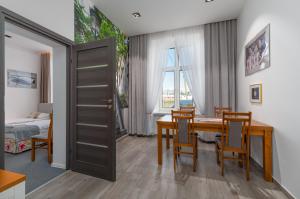 jadalnia ze stołem i krzesłami oraz sypialnia w obiekcie Nasze Kamienice Apartament Express Rzeszów Główny w mieście Rzeszów