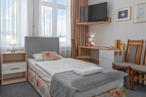 pokój hotelowy z łóżkiem i telewizorem z płaskim ekranem w obiekcie Nasze Kamienice Apartament Express Rzeszów Główny w mieście Rzeszów