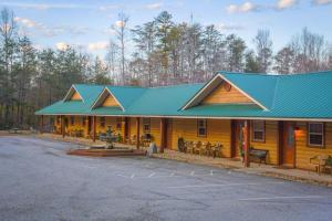 a large wooden cabin with a blue roof at Nacoochee valley motel in Clarkesville
