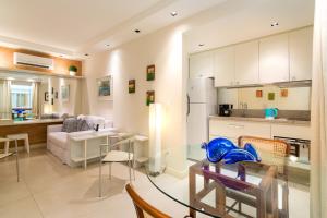 a kitchen and a living room with a glass table at MC FLATS IPANEMA BEACH STAR in Rio de Janeiro