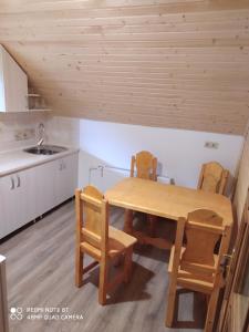 a kitchen with a wooden table and chairs at Panorama in Kvasy