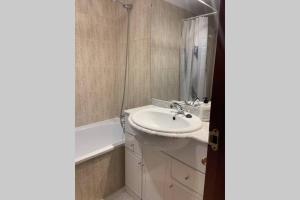 ein Badezimmer mit einem Waschbecken und einer Badewanne in der Unterkunft Apartamento en el Paseo de Manuel Noriega, Nº 9, con jardín privado, Wifi, en Comillas in Comillas
