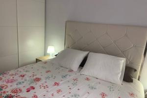 1 dormitorio con 1 cama con colcha de flores en Apartamento en el Paseo de Manuel Noriega, Nº 9, con jardín privado, Wifi, en Comillas, en Comillas
