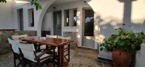 a wooden table and chairs on a patio at Anemomylos Houses in Koufonisia