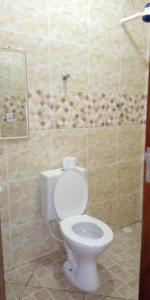 een badkamer met een wit toilet in een kamer bij Casa Bairro Belas Artes in Itanhaém
