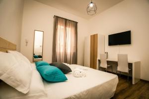 Schlafzimmer mit einem Bett mit blauen Kissen und einem Schreibtisch in der Unterkunft Hostly - Nicole Apartment Pontedera - 2BR in Full Center in Pontedera