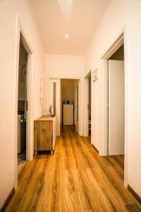 einen leeren Flur eines Apartments mit Holzböden in der Unterkunft Hostly - Nicole Apartment Pontedera - 2BR in Full Center in Pontedera