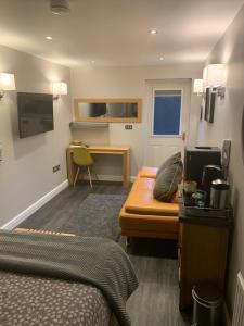 a hotel room with a bed and a couch and a desk at The Ashfield in Sutton in Ashfield