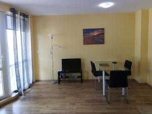 a living room with a table and chairs and a lamp at Tvardica Apartment in Burgas City