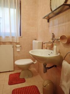 a bathroom with a white sink and a toilet at Katja Beach Apartment in Račišće