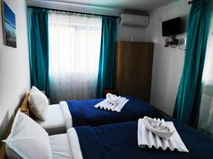 a bedroom with two beds with towels on them at Splendoarea Deltei in Maliuc