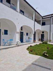 einen Innenhof eines weißen Gebäudes mit einem Garten in der Unterkunft Suite FURORE in Aversa