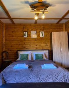 um quarto com uma cama grande e lençóis azuis em Тихият кът em Sapareva Banya