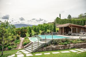 a swimming pool in a garden with a house at Huebenburg in Appiano sulla Strada del Vino