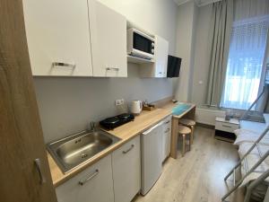 a small kitchen with a sink and a microwave at Apartamenty Olsztyn in Olsztyn