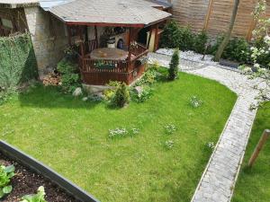 een achtertuin met een tuinhuisje en een tuin met gras bij Casa Vivaldi in Velingrad